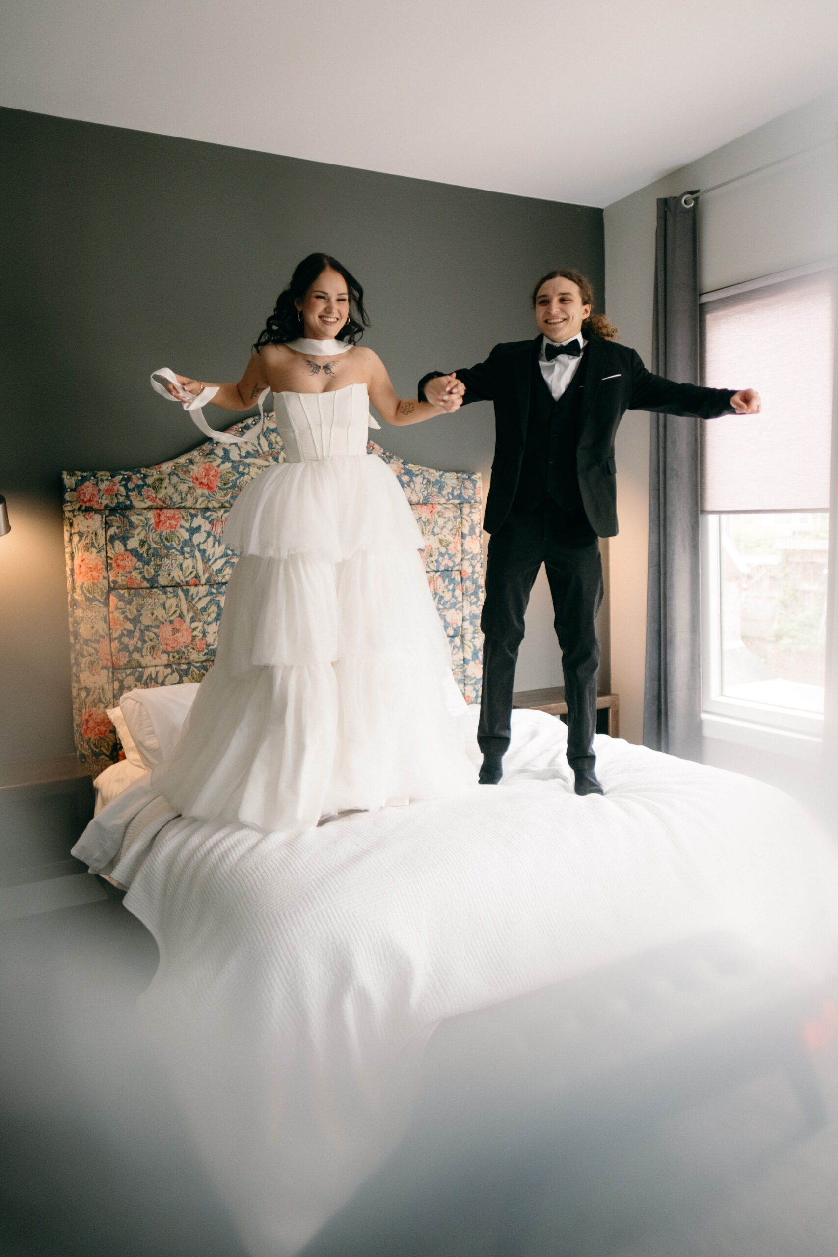 bride and groom holding hands jumping on bed townley house easton wedding photography documentary
